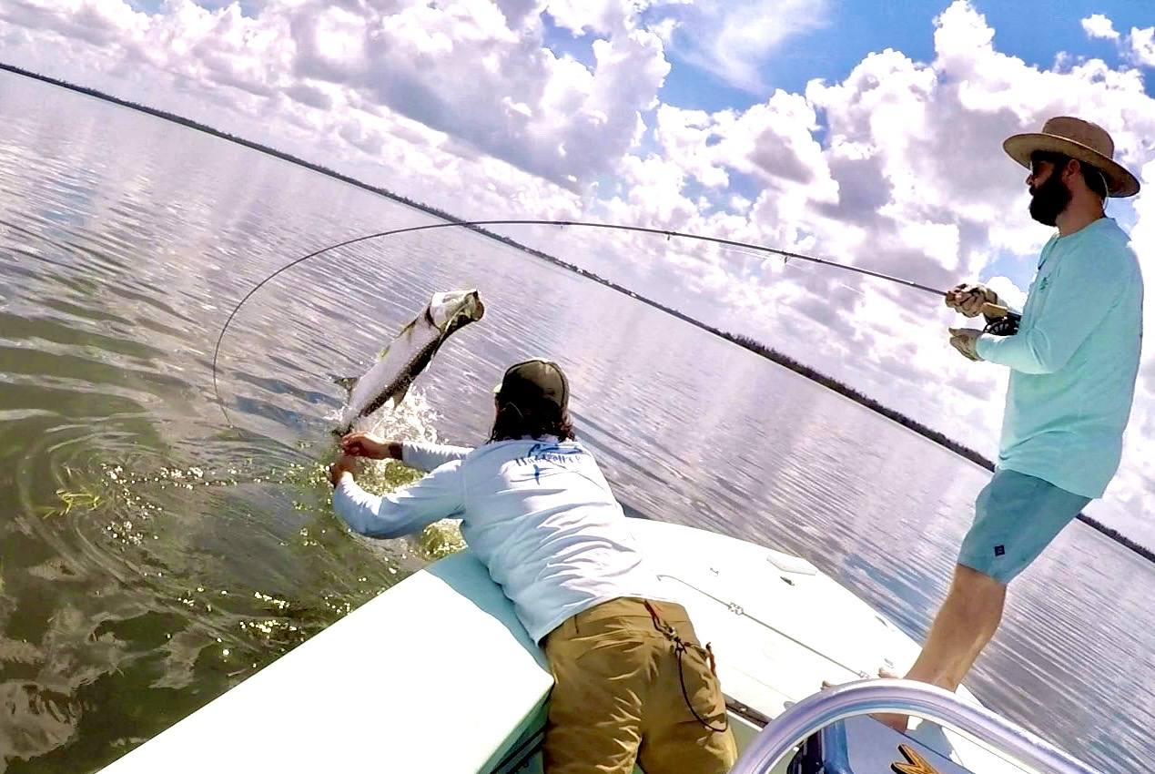 Casting from the bow under big Florida clouds