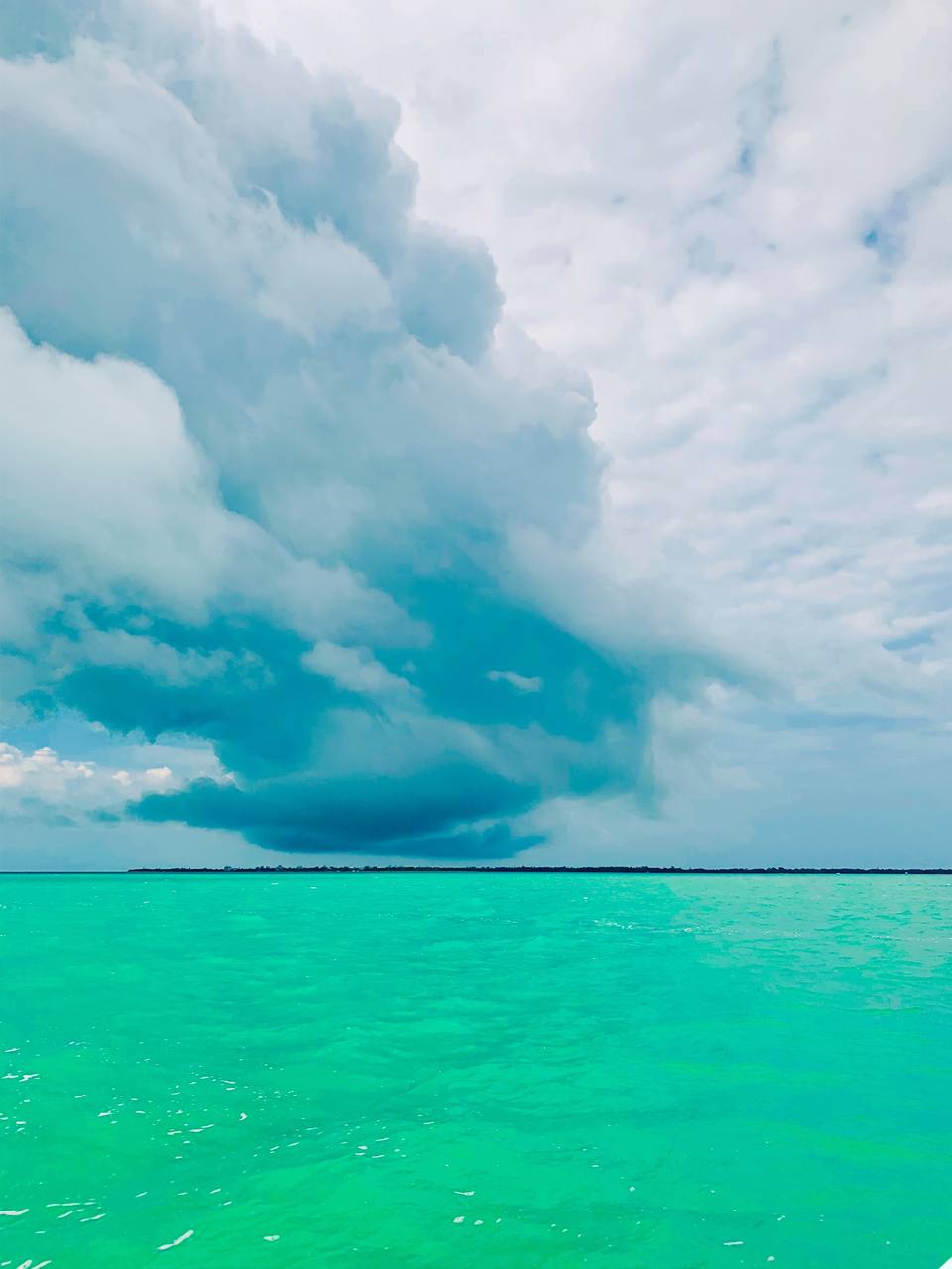 Turquoise water and towering clouds over the barrier islands